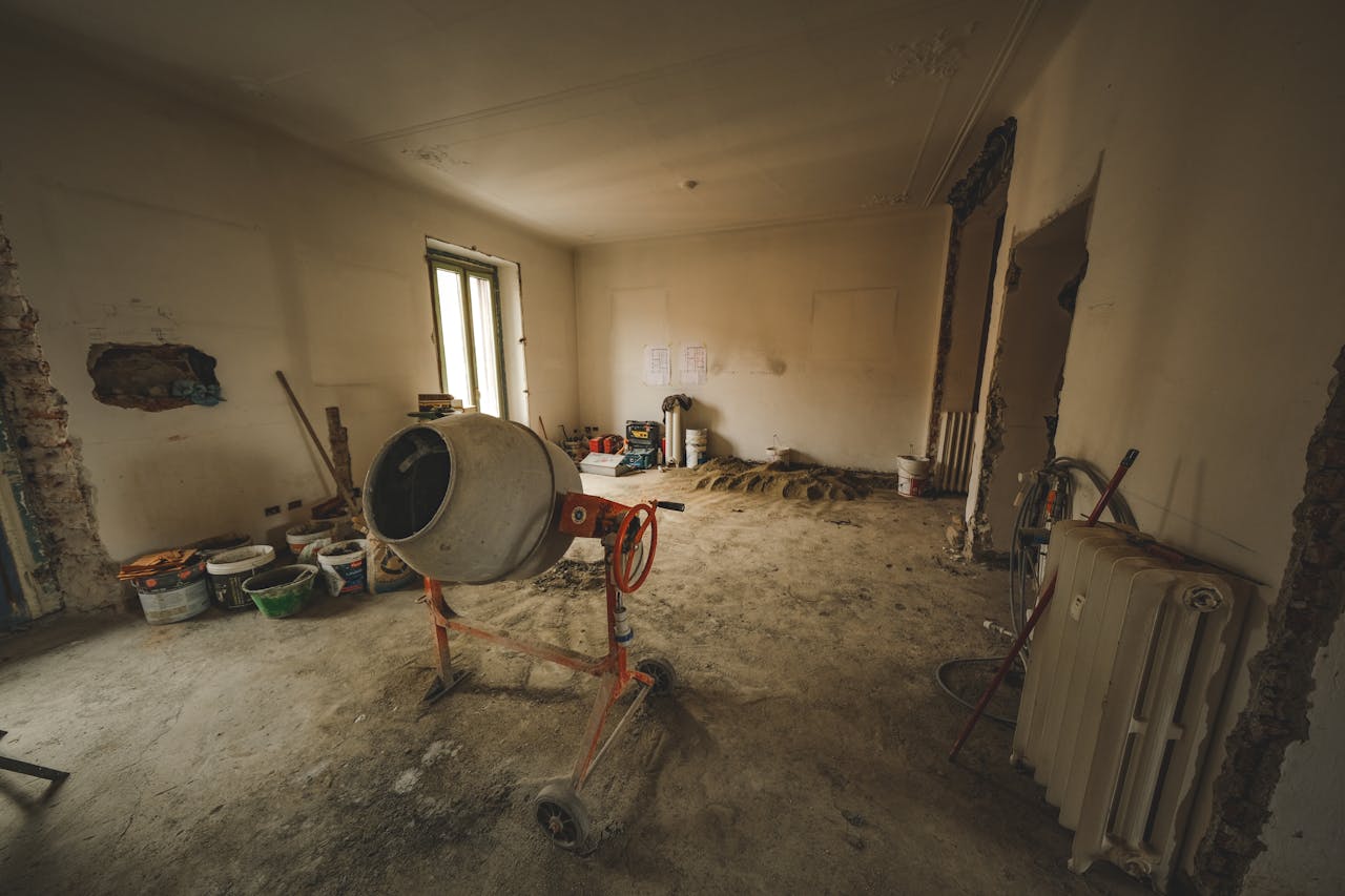 about-01 Empty room with a concrete mixer and tools, ideal for renovation concepts.