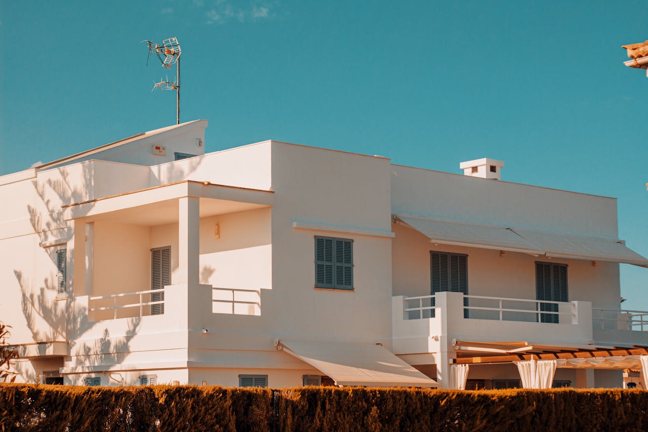 gallery-6 Elegant modern white house with balconies under a clear blue sky in Spain, showcasing minimalistic architecture.