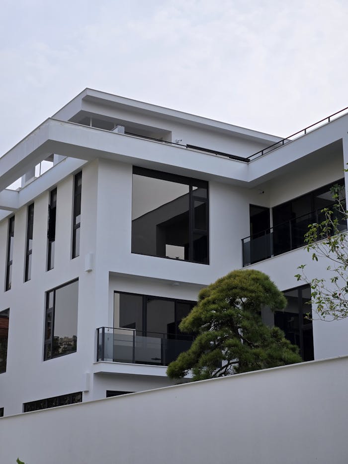 services-01 A sleek modern white building with large glass windows and minimalistic design.