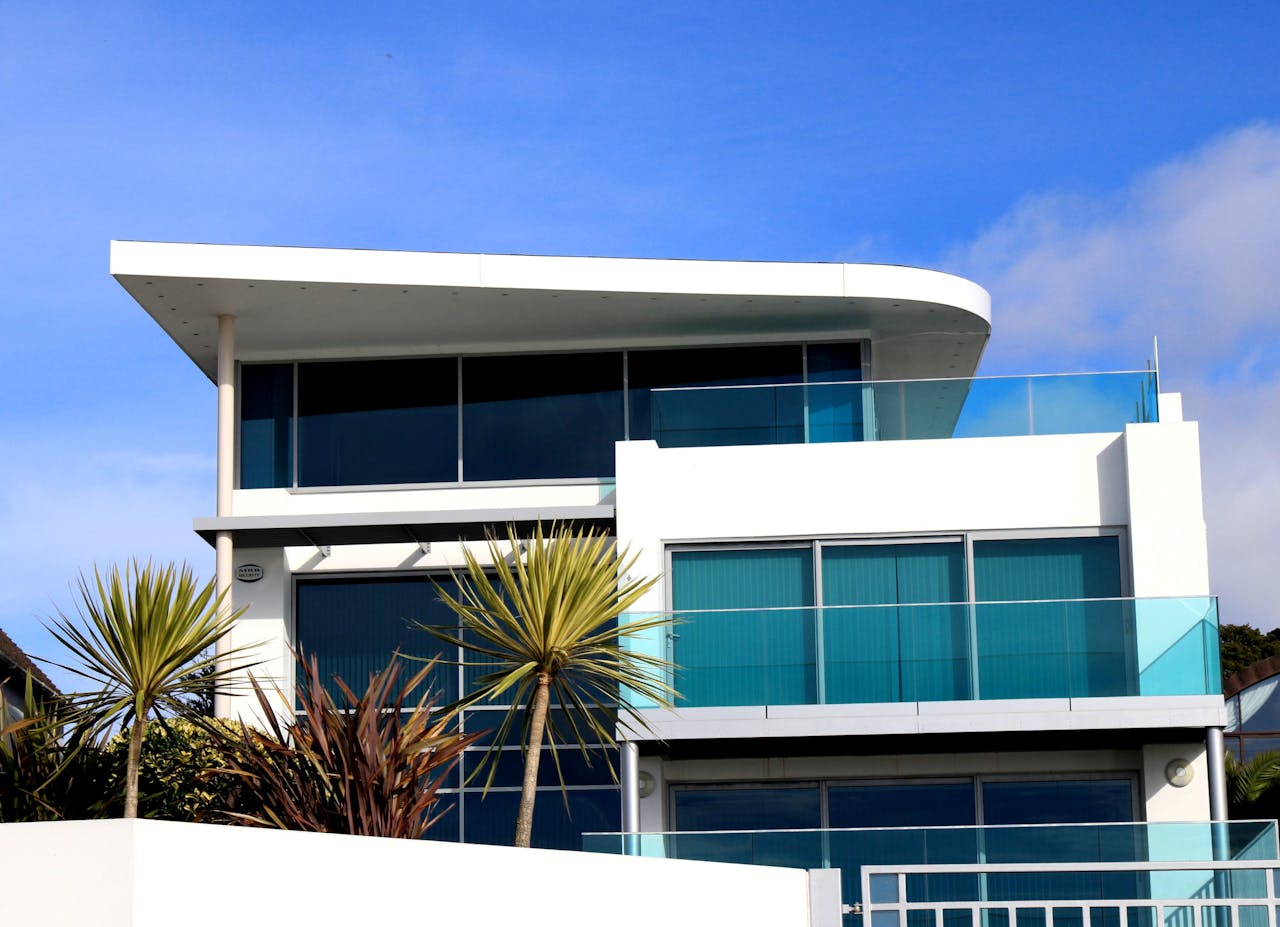 services-02 Sleek modern house with glass facade in Poole, UK under blue sky.