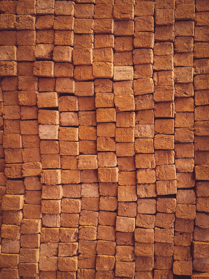 Close-up view of neatly stacked red bricks showcasing texture and pattern.